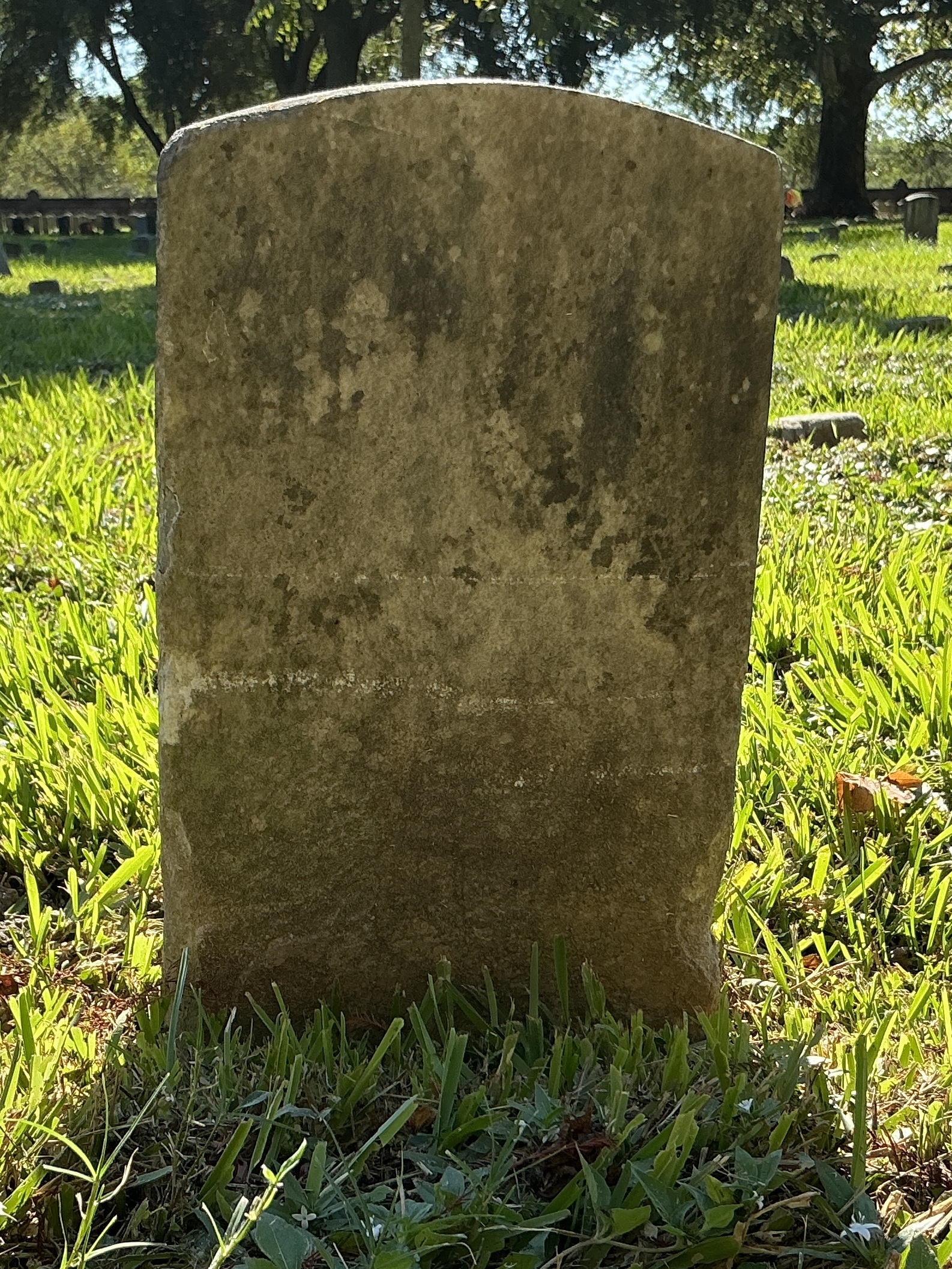 Back of historic upright marble headstone with recessed shield face.