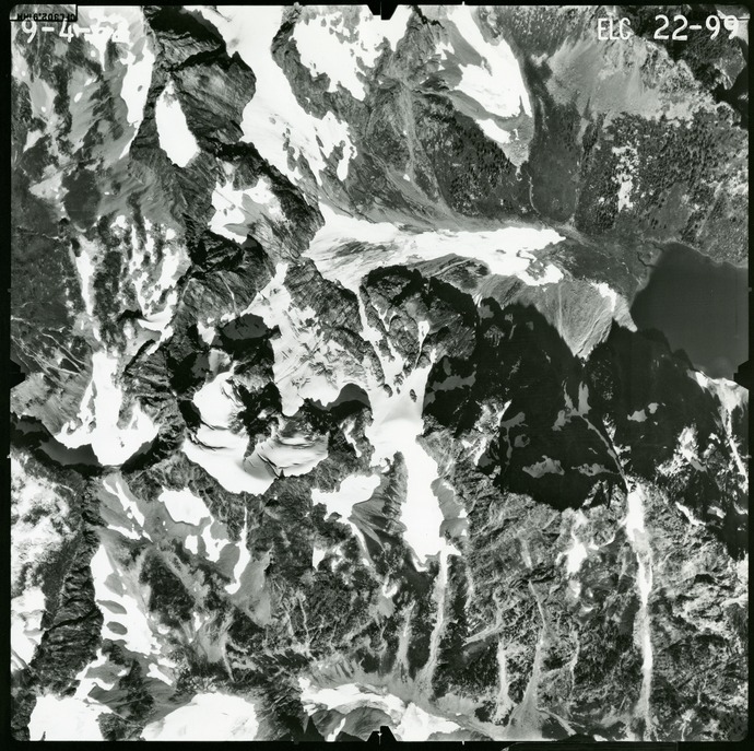 Black and white aerial photograph of glaciated mountain peaks and valleys.