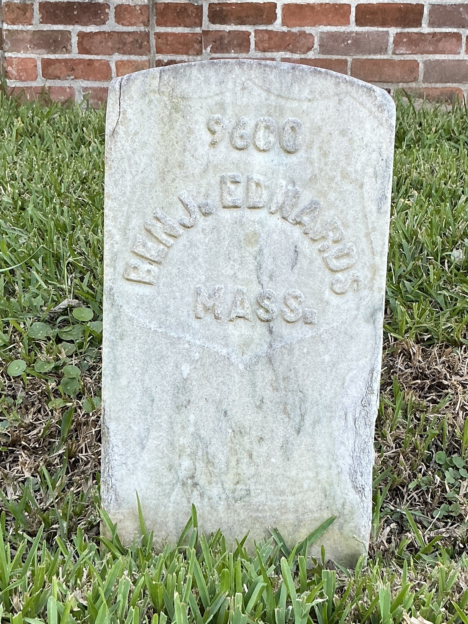 Front of historic upright marble headstone with recessed shield face.