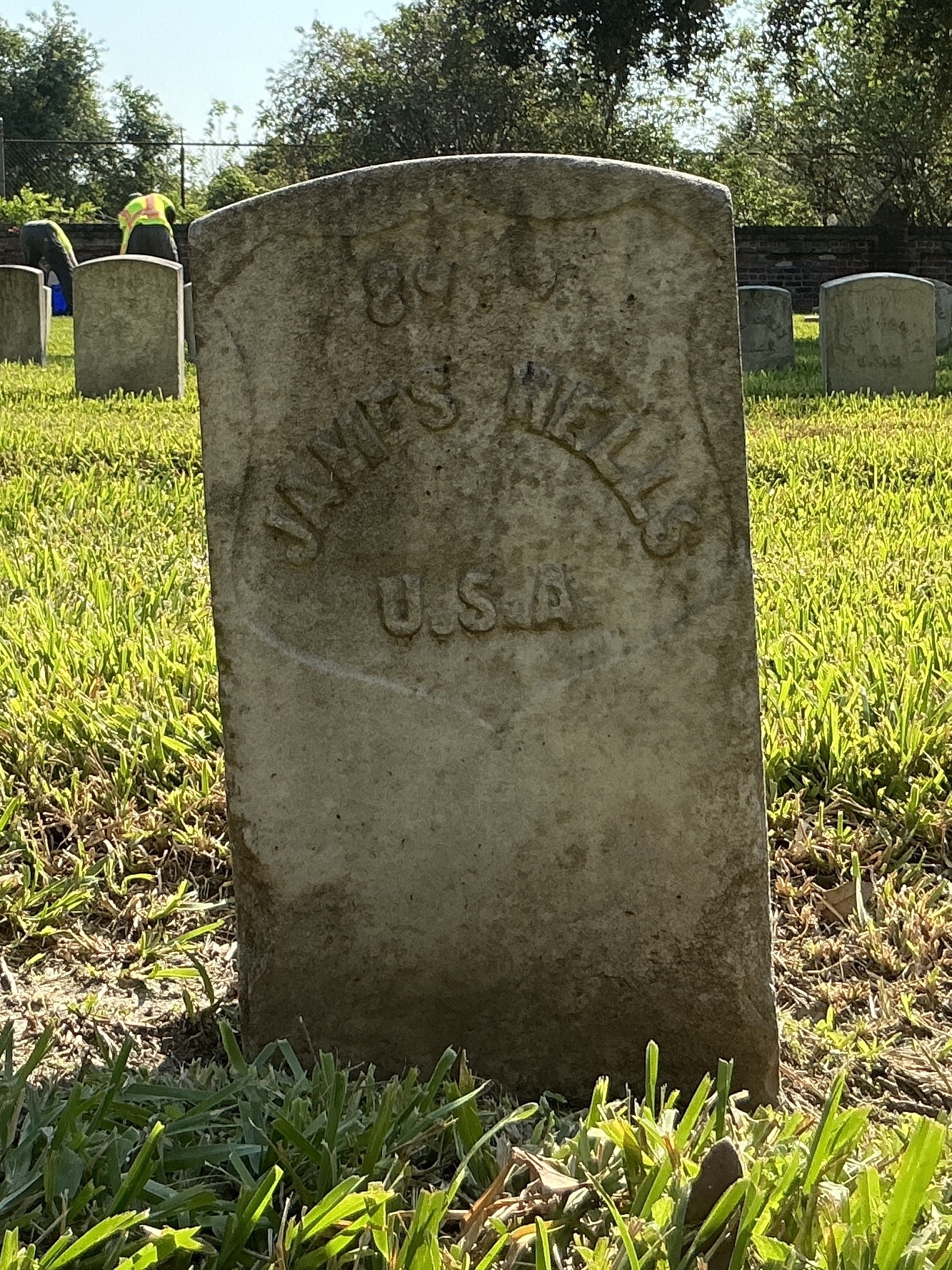 Front of historic upright marble headstone with recessed shield with recessed lettering face.