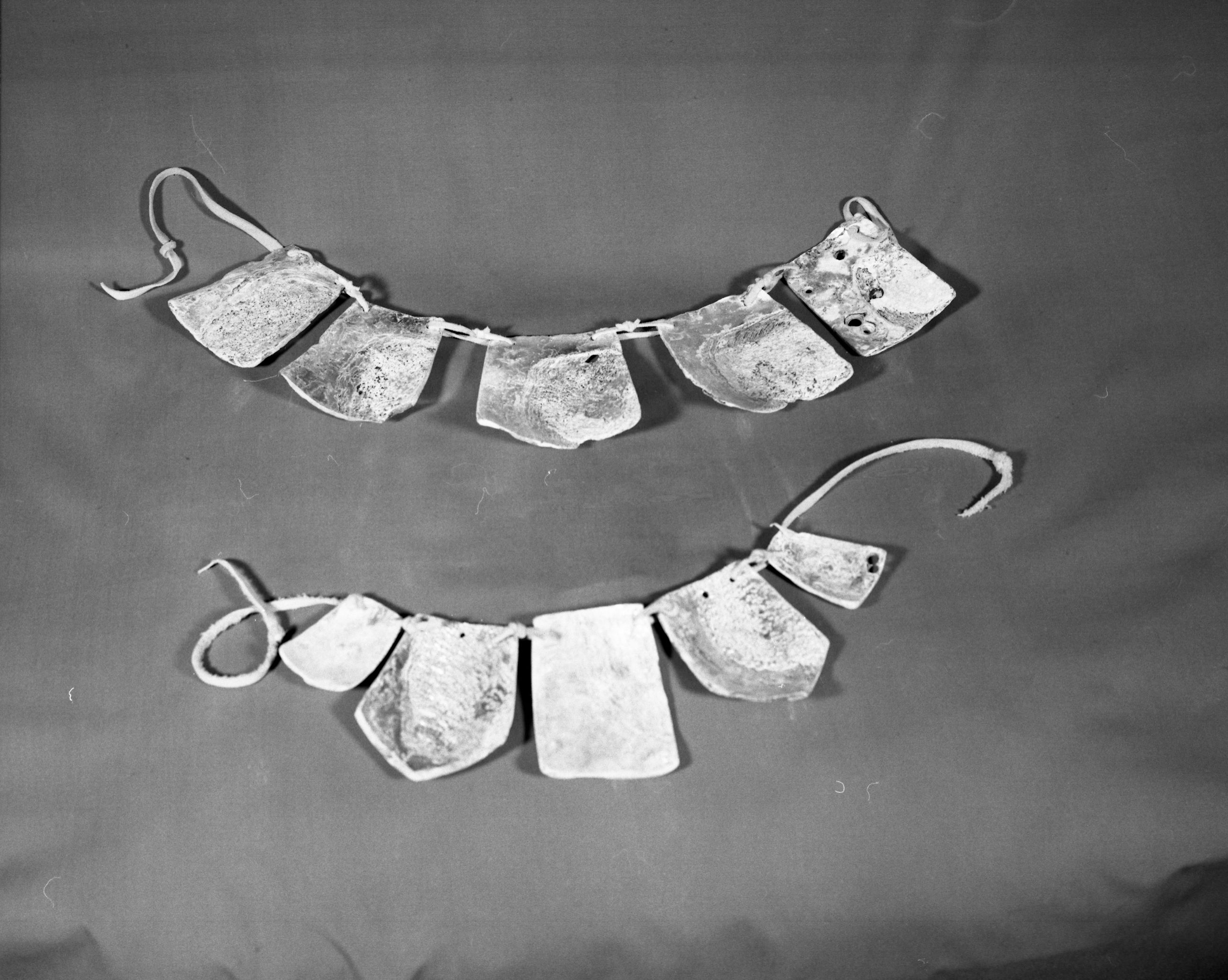 Private Collection. Object: Miwok abalone shell pieces. Dimensions: largest 4 1/2 x 4", smallest 2 1/2 x 2" two are pentagonal, rest rectangular. Technology: 10 intact pendants, one fragment of finished pendant, & remainder 16 pieces of abalone shell, most of which show cut marks and grinding, including hinge fragment apparently waste material from manufacture of pendants on site. Found with pieces of "iron-stone" ware. Collection History: Found while plowing sometime between 1900 and 1915 near Curtis or Blanket Creek. Photographed by Michael Dixon. Catalogued by Craig Bates and Barbara Beroza. Yosemite Collections, National Park Service.