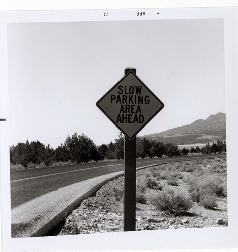 Road sign reading 'Slow Parking Area Ahead' in Kolob Canyon.