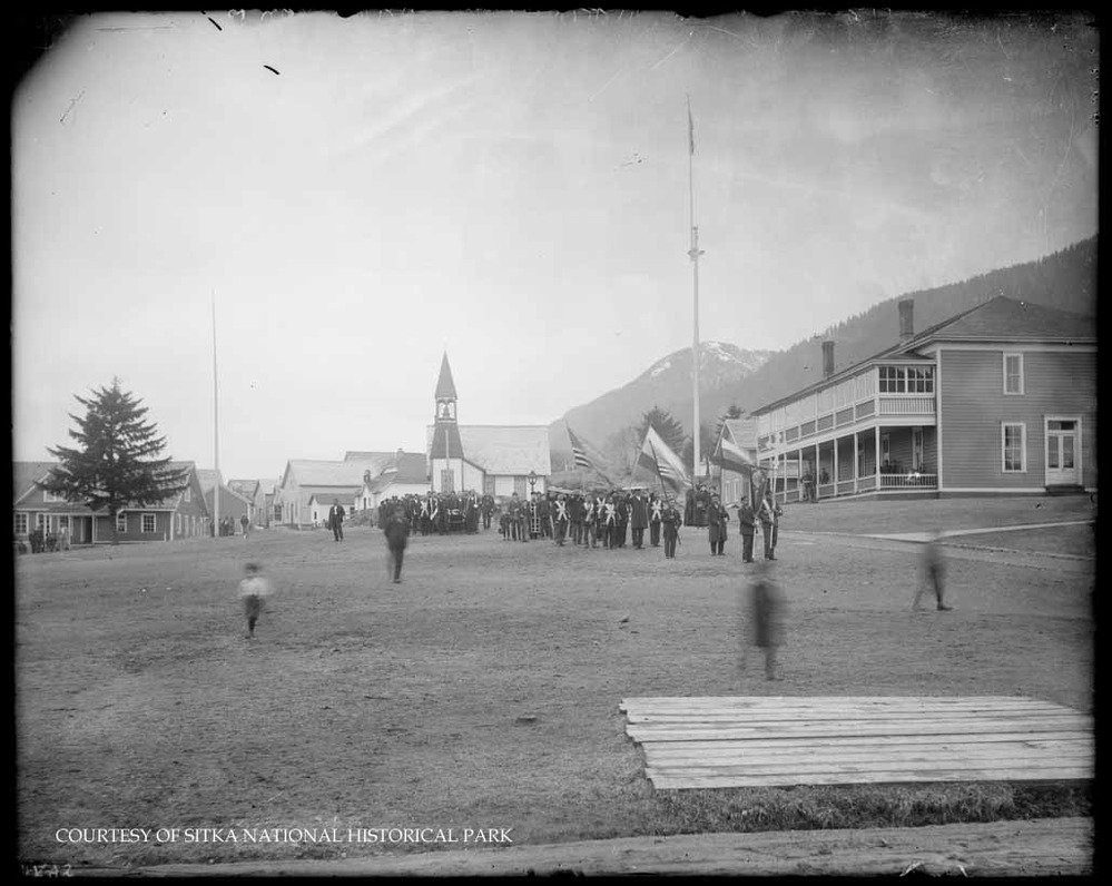 Funeral procession across the parade ground, preceded by a band.