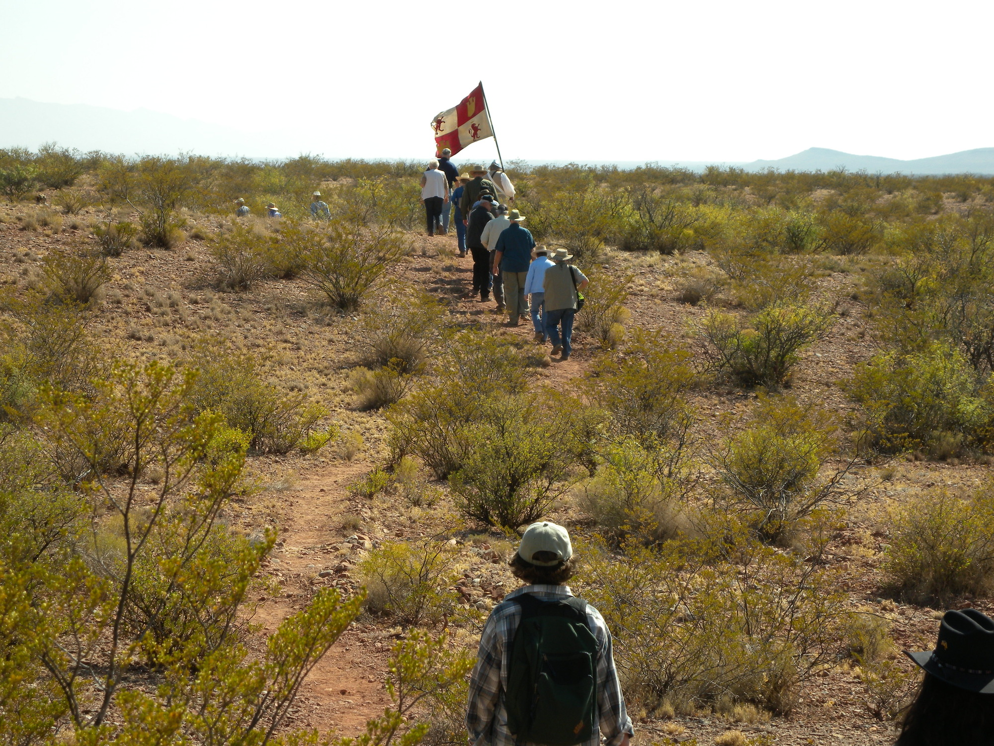 A group of people walking through a desert.