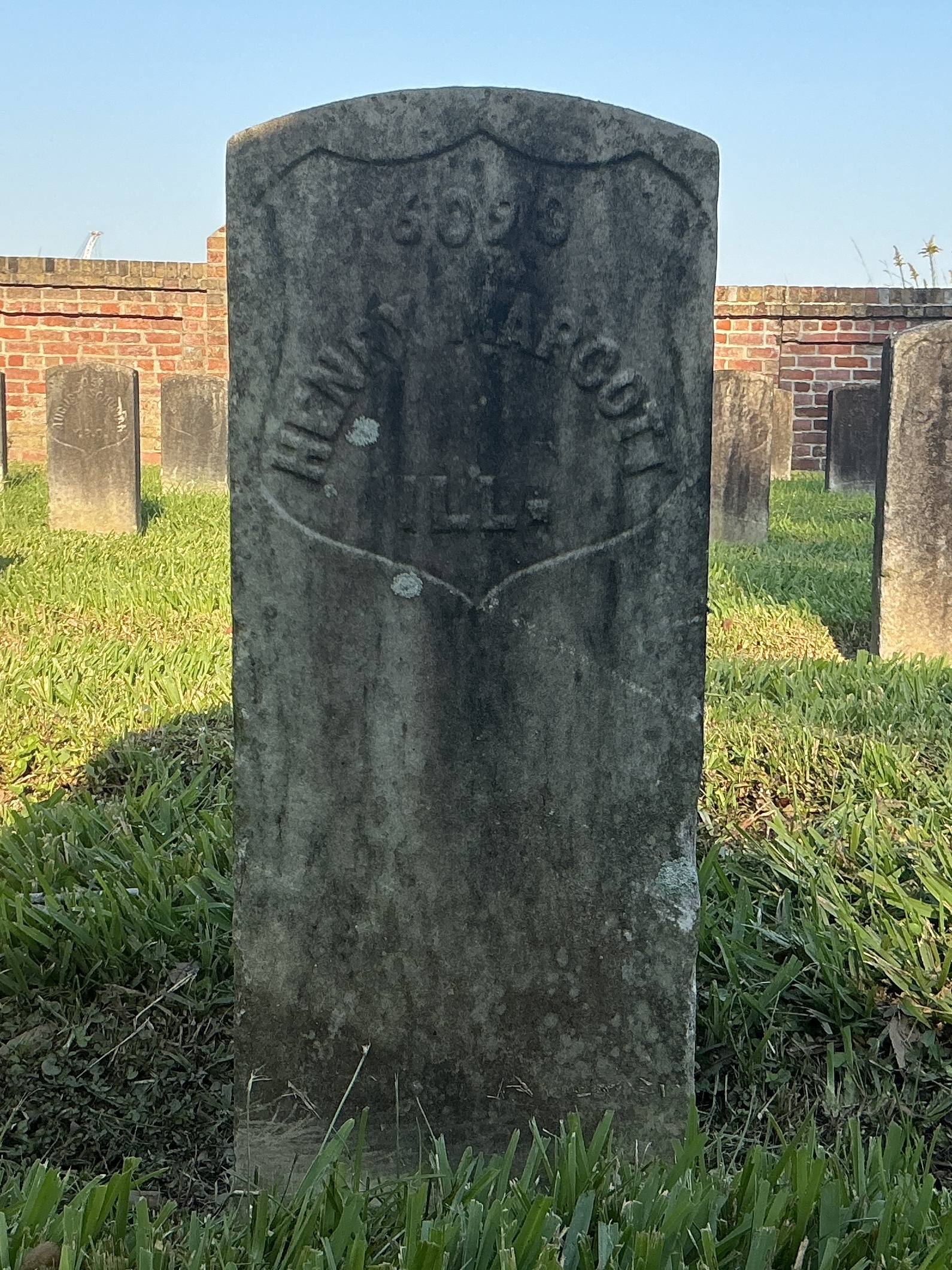 Front of historic upright marble headstone with recessed shield face.