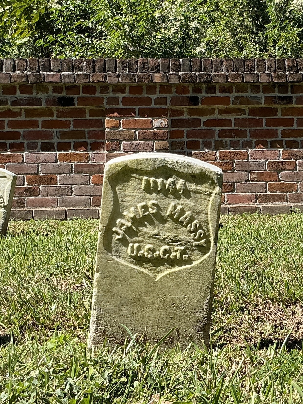 Front of historic upright marble headstone with recessed shield face.