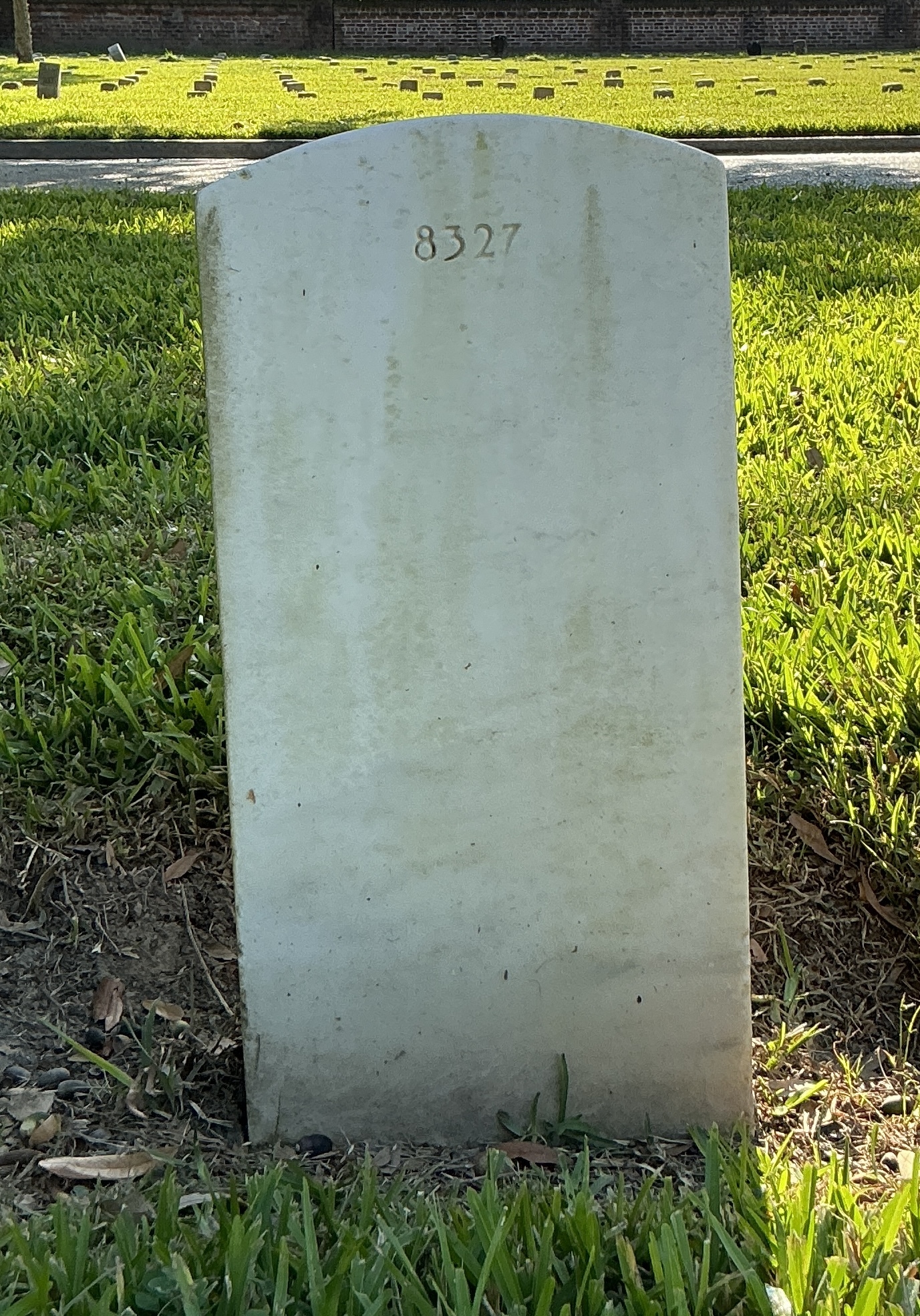 Back of historic upright marble headstone with recessed shield with recessed lettering face.