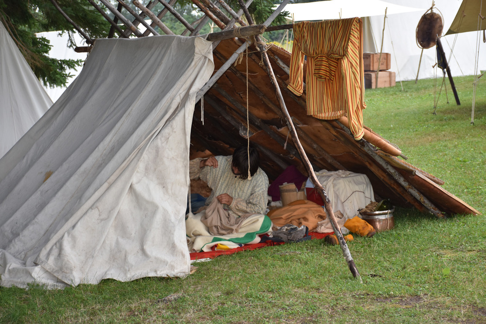 Reenactor inside a white canvas tent.