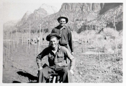 Two Civilian Conservation Corps (CCC) men riding in wheel barrow near the South Entrance.