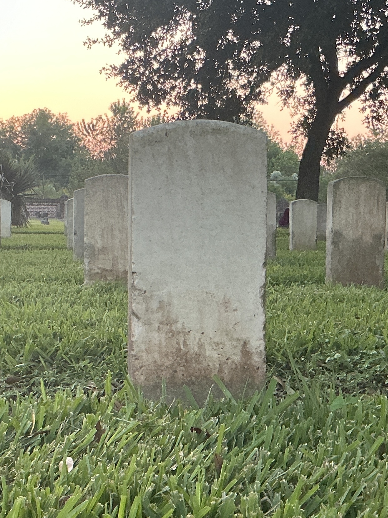 Back of historic upright marble headstone with recessed shield face.