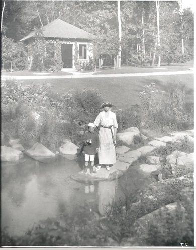 Mrs. Pulitzer and son at spring pool