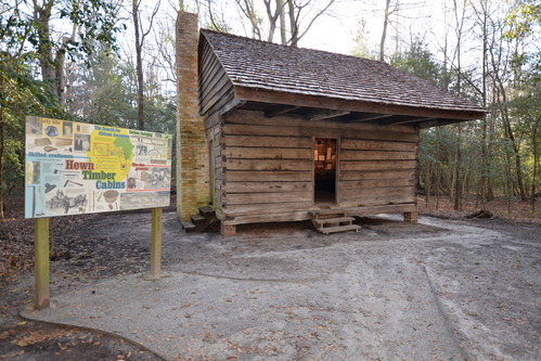 Wooden structure with brick chimney to the right.