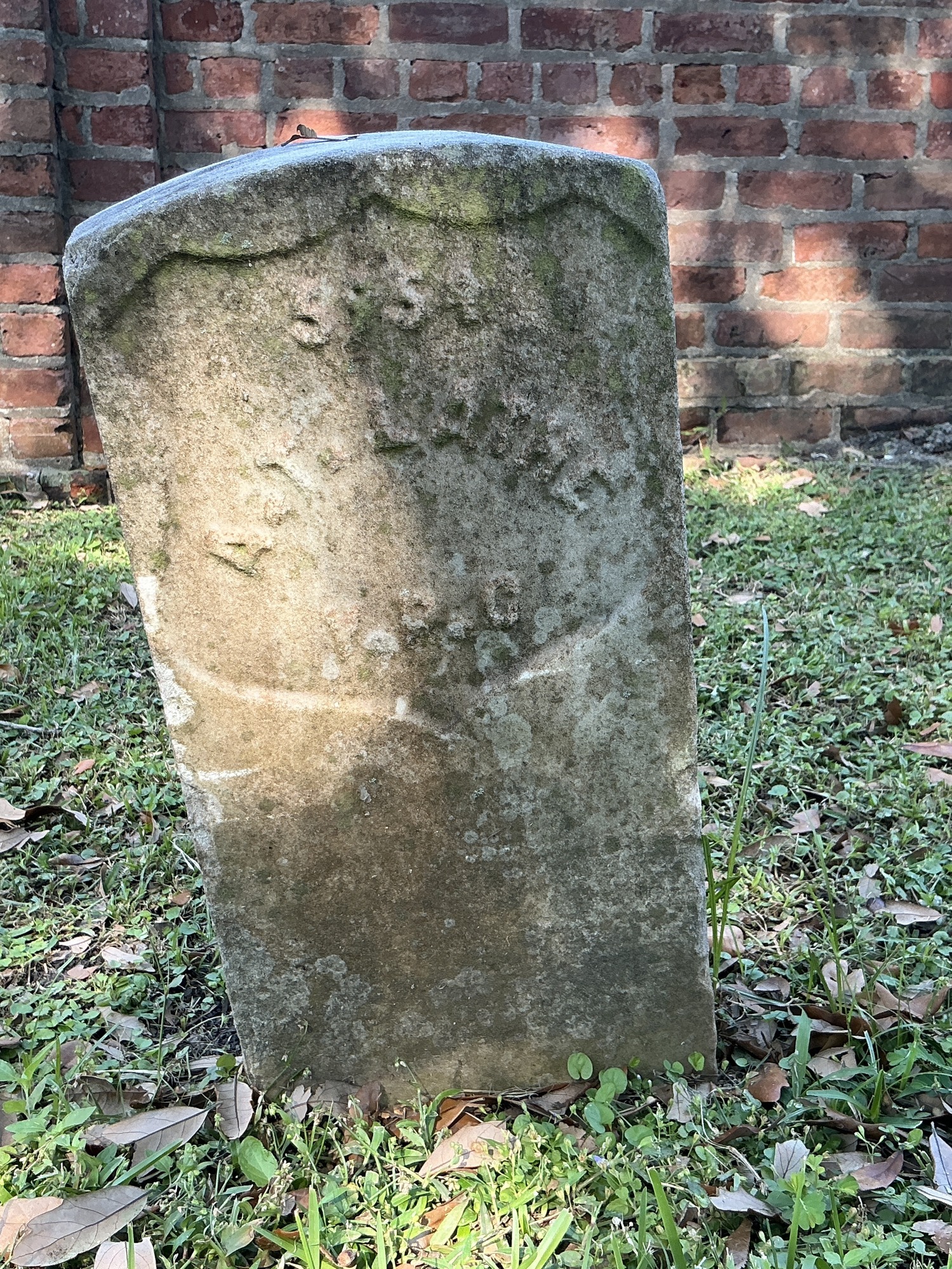 Front of historic upright marble headstone with recessed shield face.