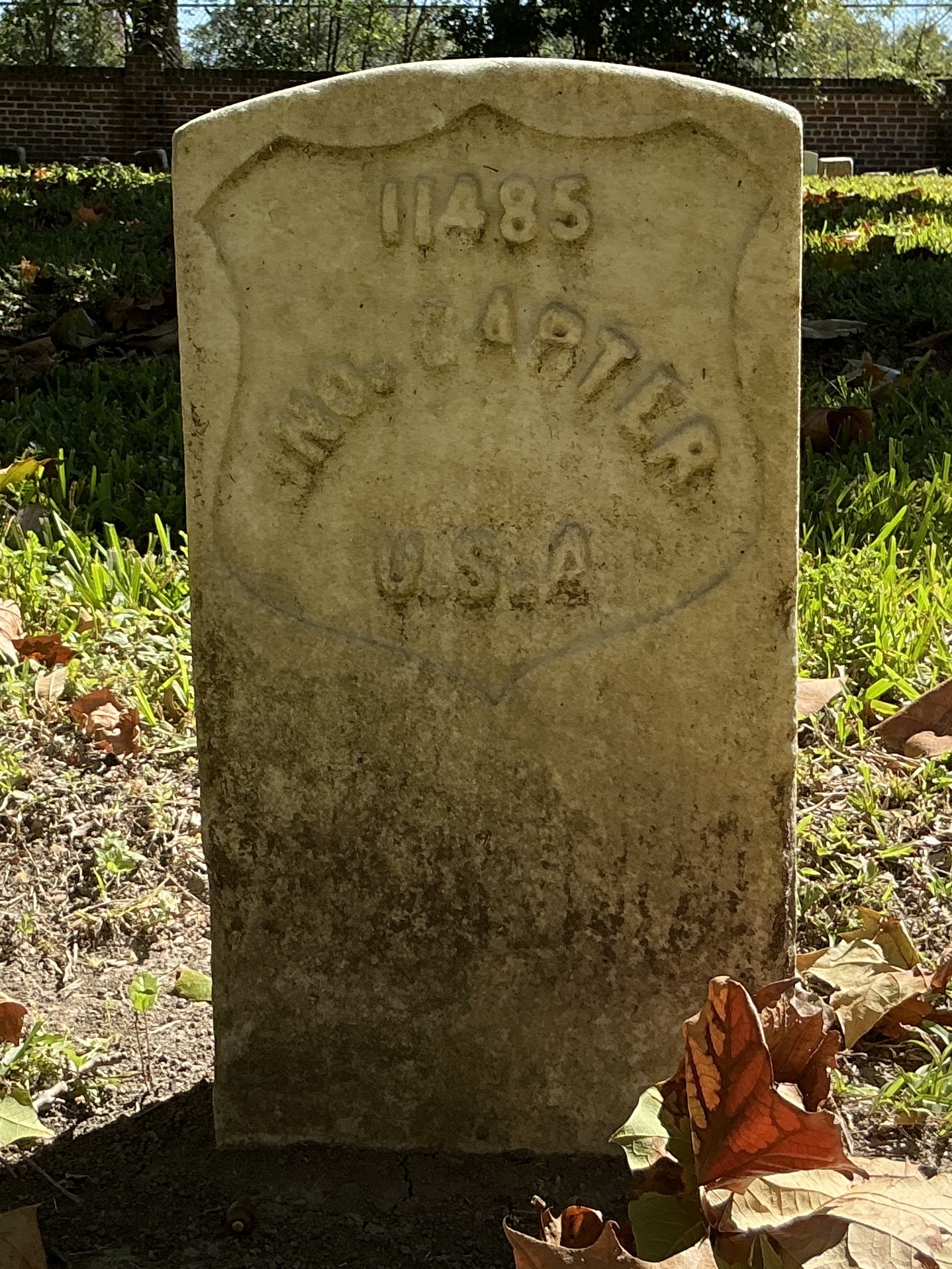 Front of historic upright marble headstone with recessed shield face.