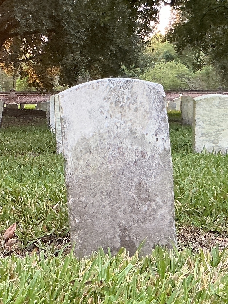 Back of historic upright marble headstone with recessed shield face.