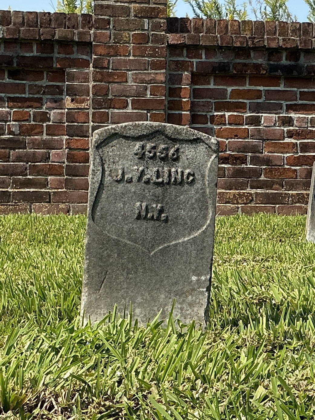 Front of historic upright marble headstone with recessed shield face.