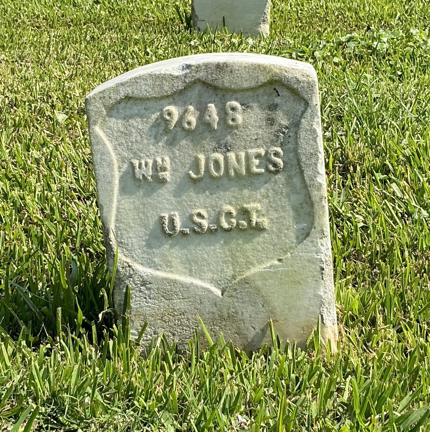 Front of historic upright marble headstone with recessed shield face.