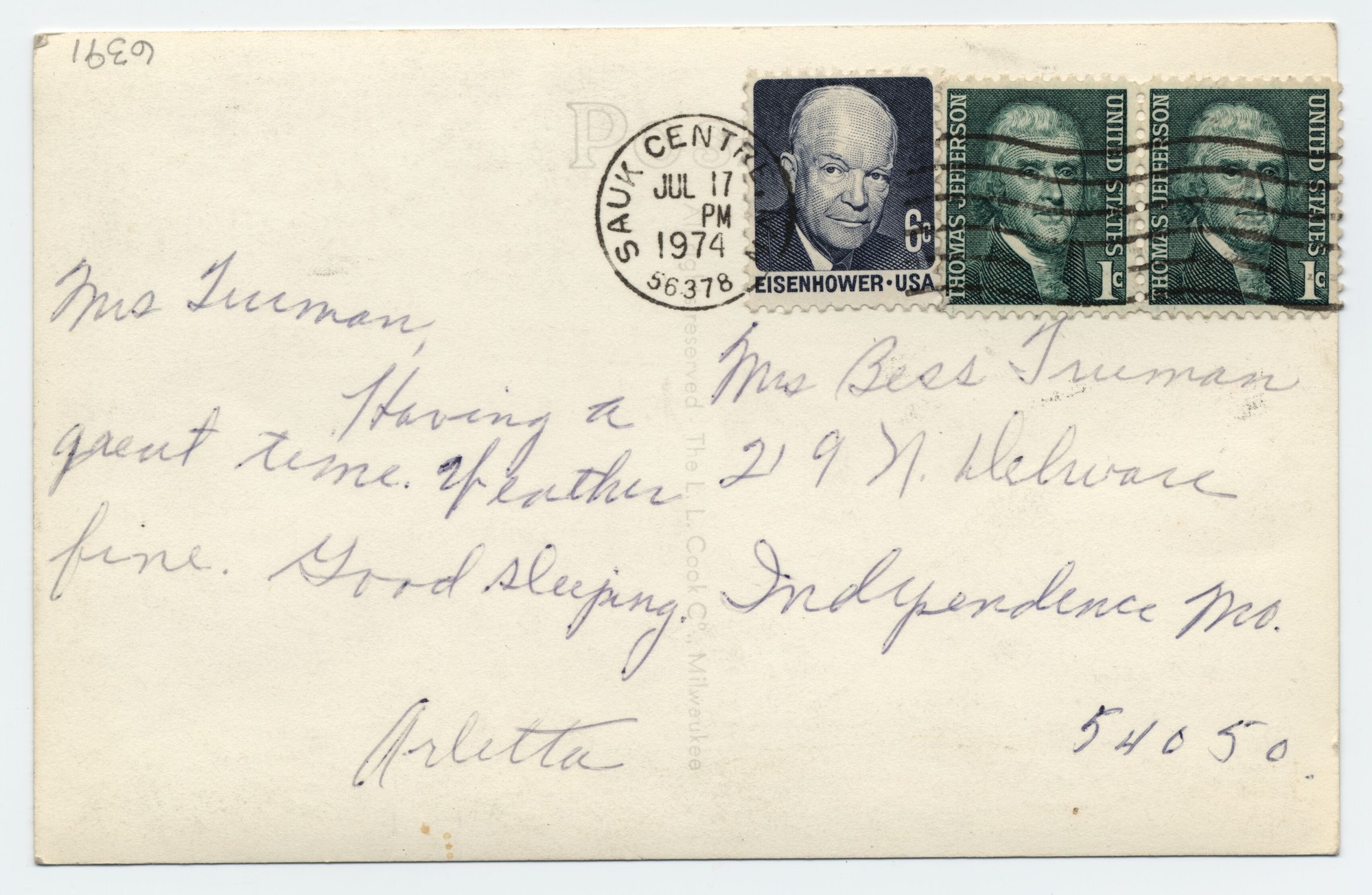 A postcard with a photograph of a building on a lake.