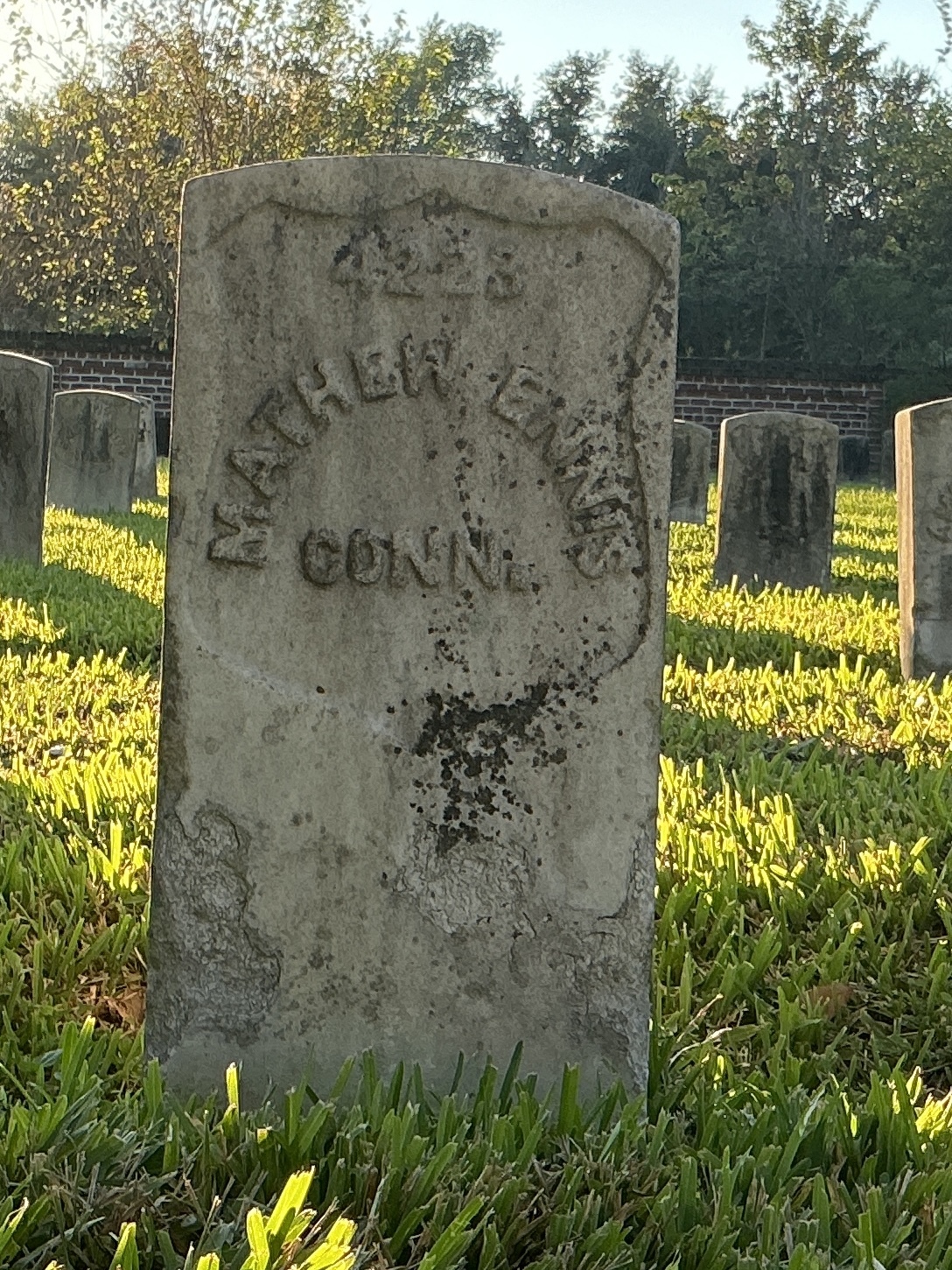 Front of historic upright marble headstone with recessed shield face.
