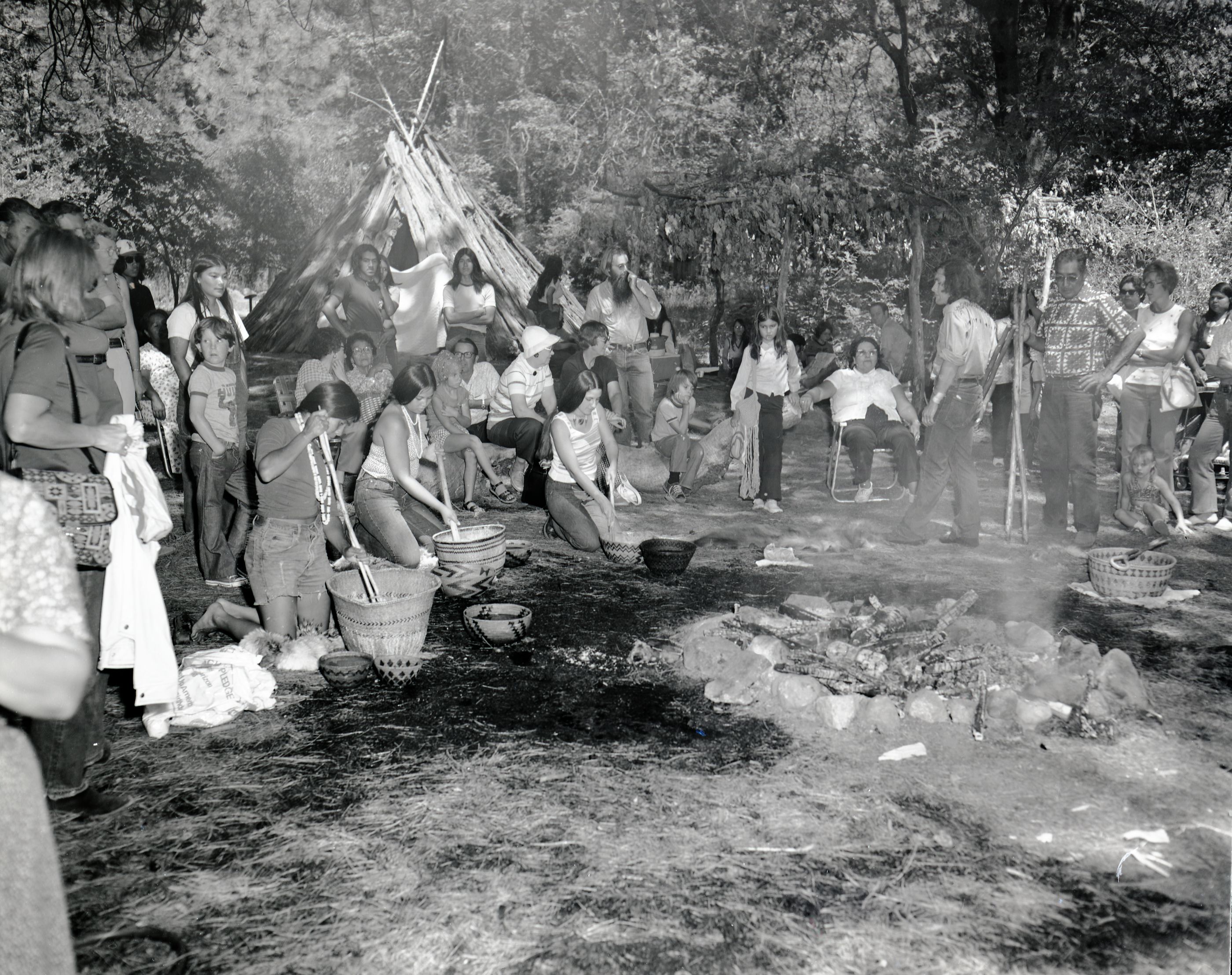 Cooking acorn mush at the Roundhouse Dedciation, Yosemite Valley. Cooking mush at the baskets (L to R): Lucy (Furr) Parker, Kimberly Stevenot, Gael Amend, sitting in the folding chair - Rosalie Bethel, standing Craig Bates and (with sticks in hand) Nelson Hopper.