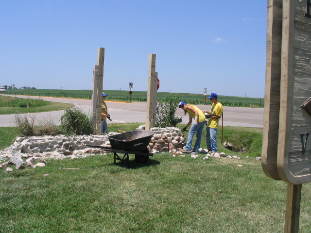 Three YCC workers working on old sign base demolition at HOME visitor center.  