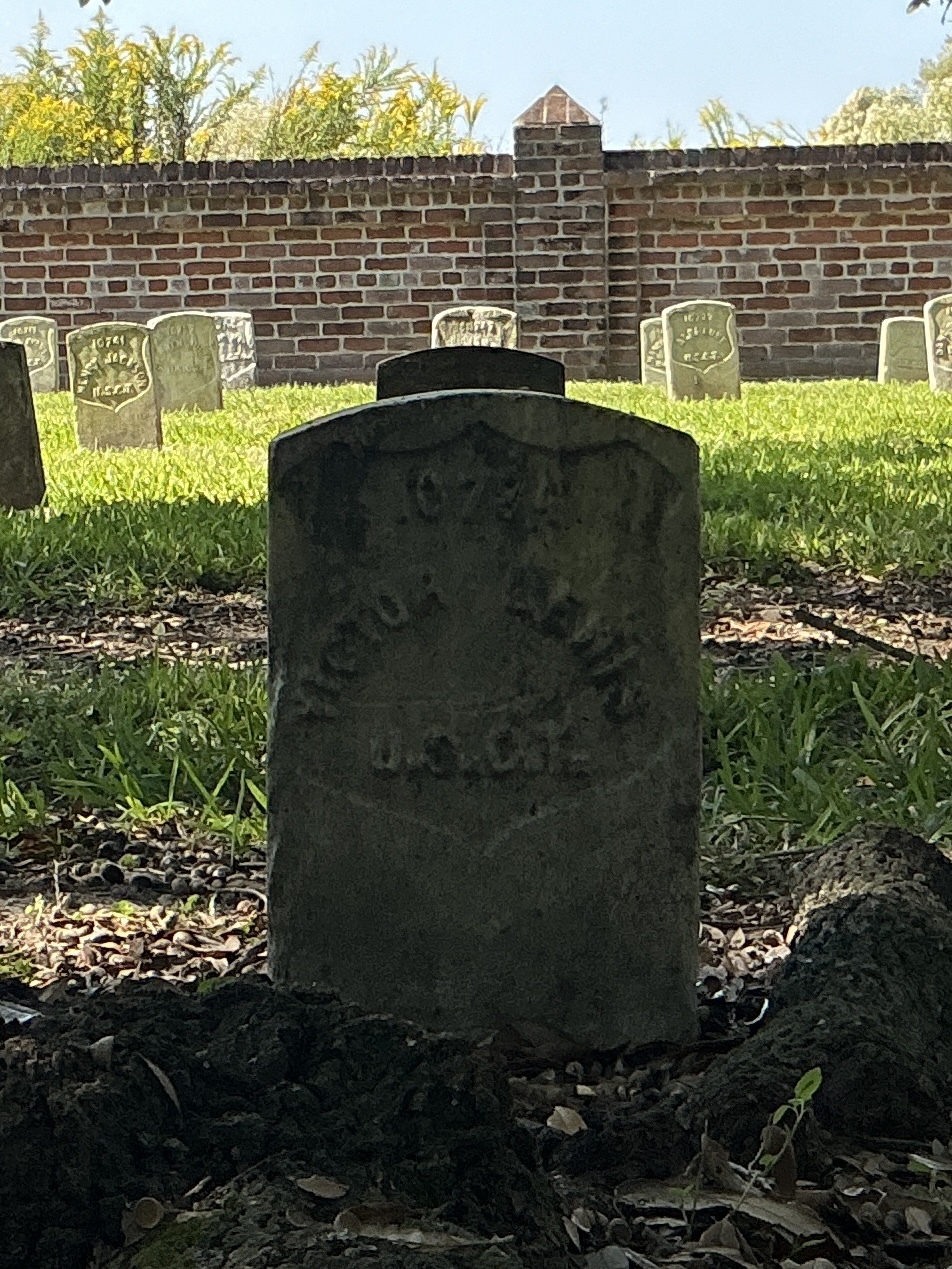 Front of historic upright marble headstone with recessed shield face.