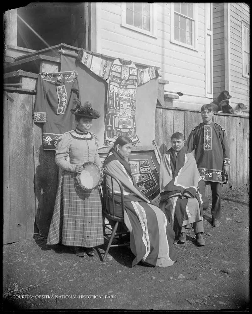 Alaska Native people displaying ceremonial regalia: button blankets and beaded shirts.