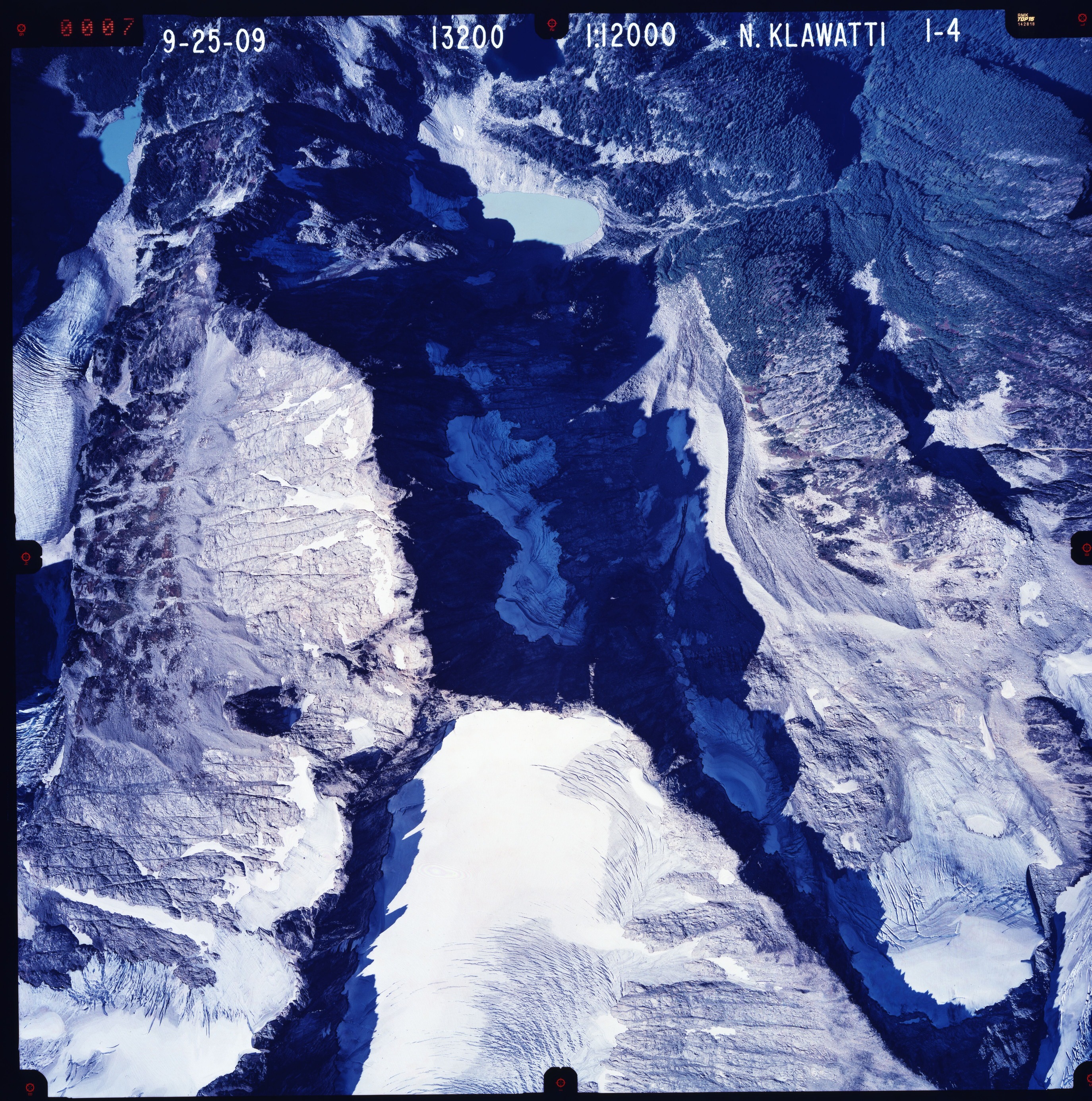 Color aerial photograph of glacier and snowfields on mountain peak.