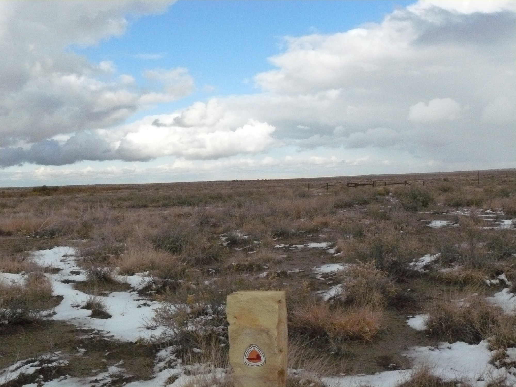 A sign outside a field with snow on the ground.