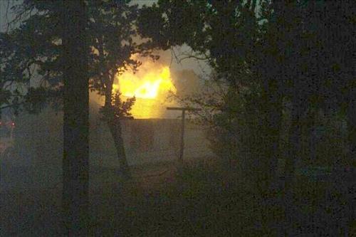 Night photos of a house burning during the Long Mesa fire in Mesa Verde National Park, July-August 2002