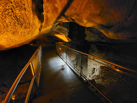 A metal bridge with handrails crosses a pit.