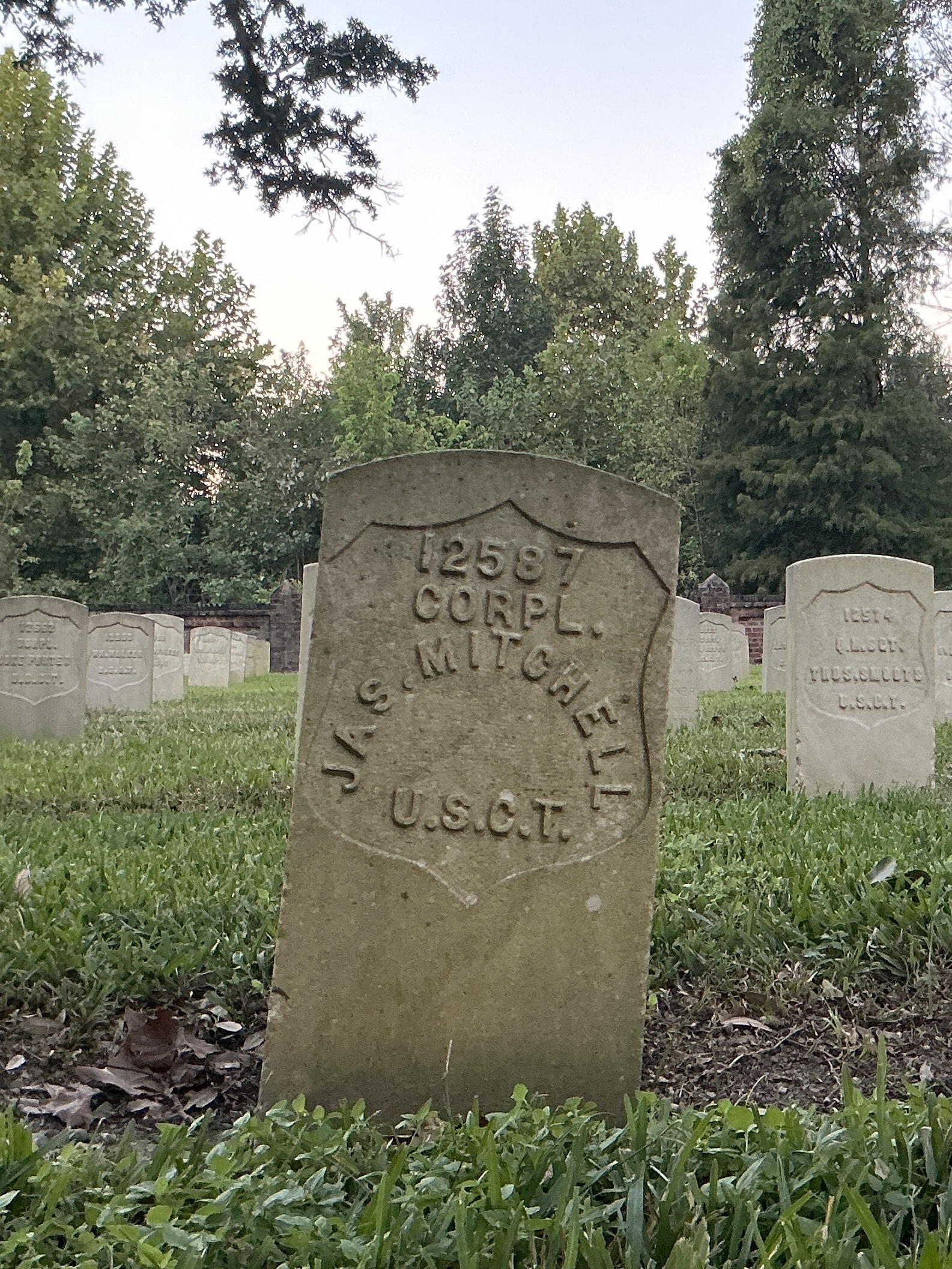 Front of historic upright marble headstone with recessed shield face.