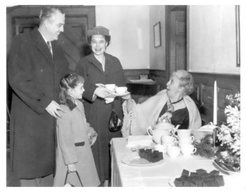 Three adults and one child standing next to a treat table