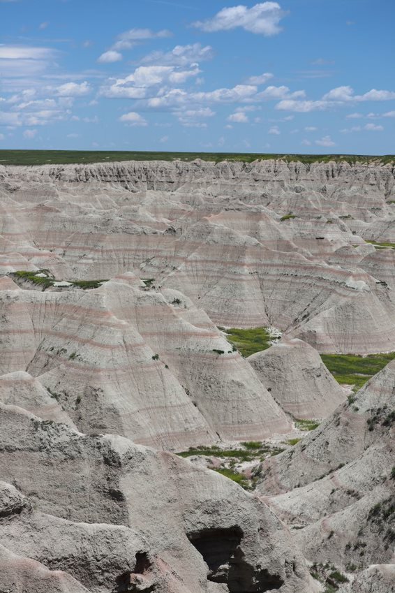formations capped with green prairie containing reddish-orange rock layers