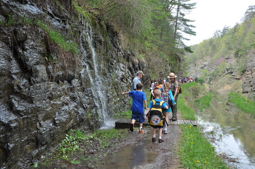 Students standing between a stone wall and the watered canal bed