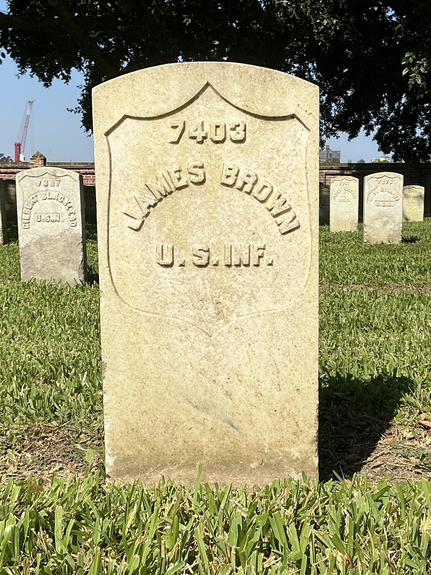 Front of historic upright marble headstone with recessed shield face.