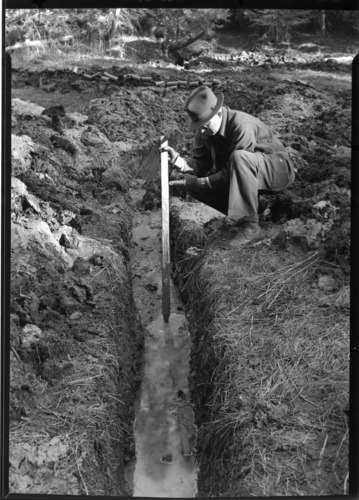 Carlton Smith measuring depth of mud.