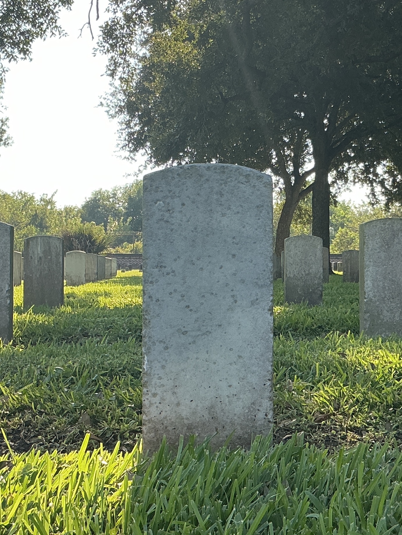 Back of historic upright marble headstone with recessed shield face.