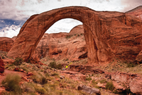 Photograph of Rainbow Bridge, Rainbow Bridge National Monument. The bridge is 88 m (290 ft) tall from its base to the top of the arch, and spans 84 m (275 ft) across the creek channel. The top of the arch measures 13 m (42 ft) thick and 10 m (33 ft) wide. It is nearly as tall as the Statue of Liberty.
