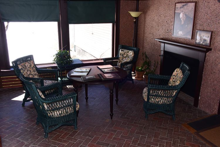 Four chairs around a table with large windows on one side, and a rocky wall on the other. 