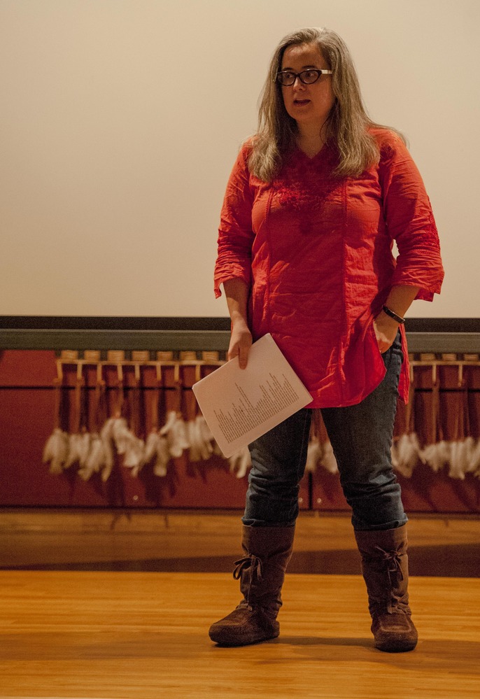 Woman standing on stage with paper in hand
