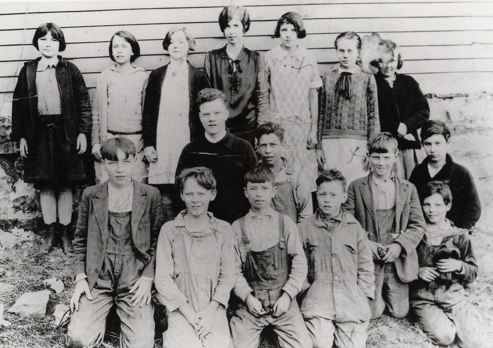 black and white photo of kids in front of a school