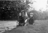 Women sitting with her two children and dog