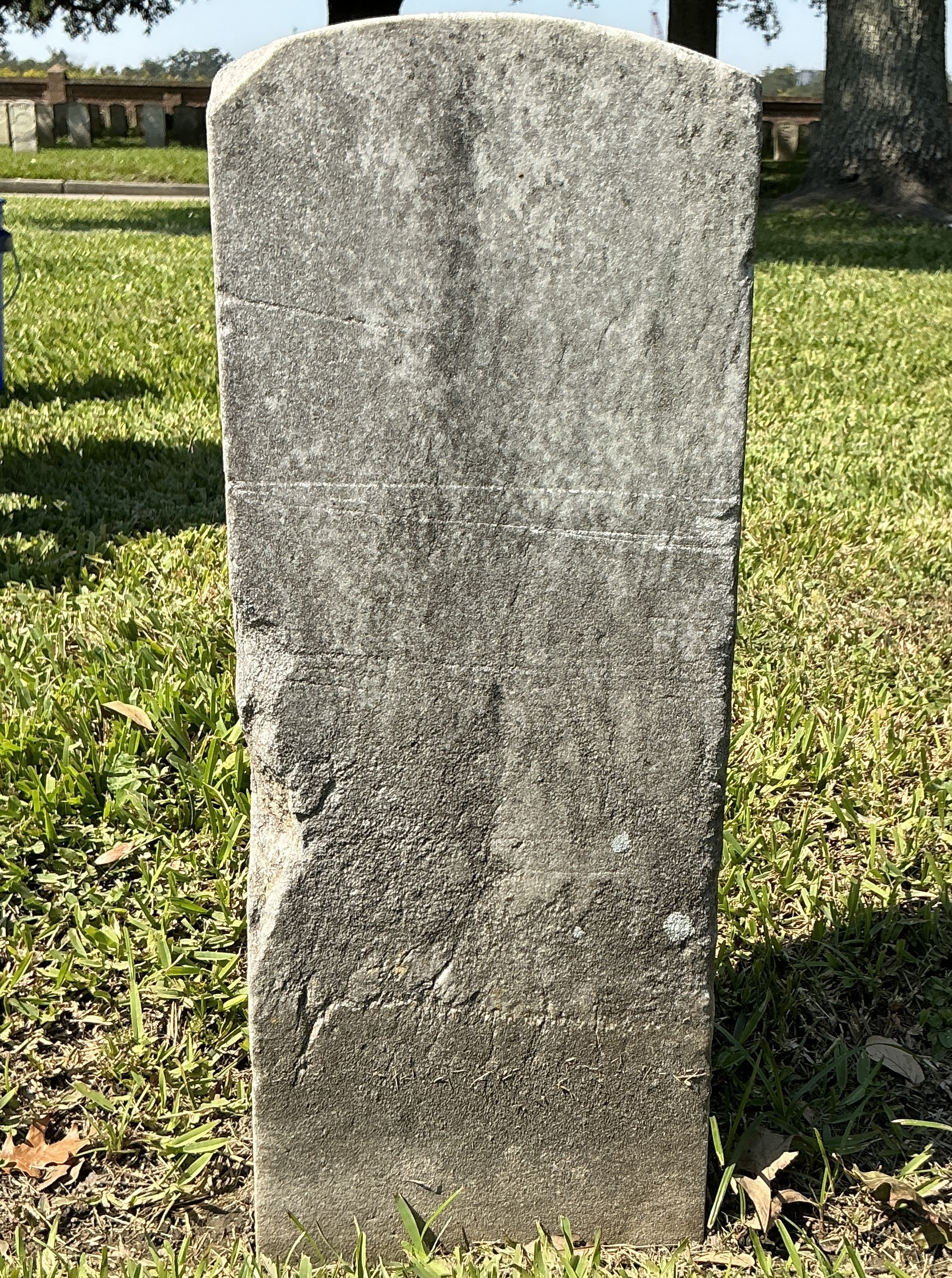 Back of historic upright marble headstone with recessed shield face.