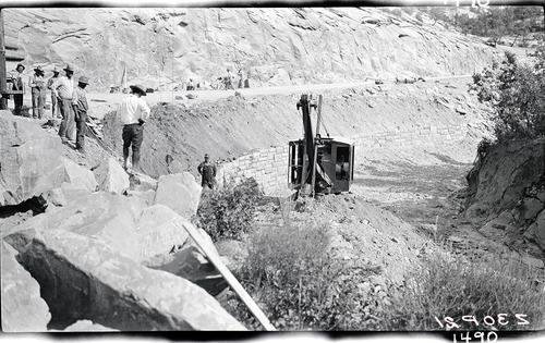 Retaining wall showing portion of completed wall. Backfilling done with park power shovel.