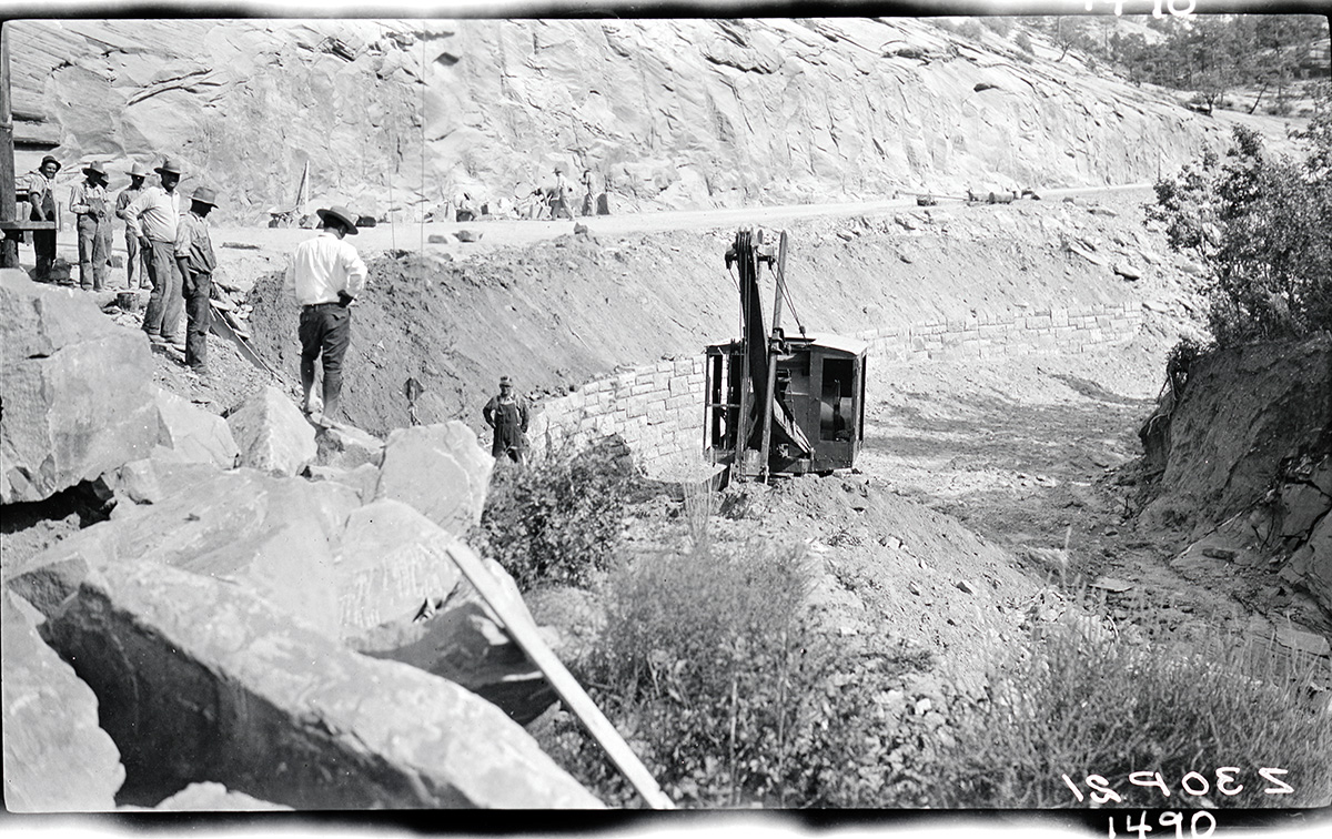 Retaining wall showing portion of completed wall. Backfilling done with park power shovel.