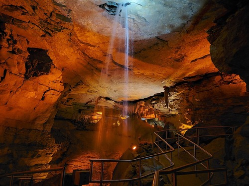 A waterfall pours into the cave from the ceiling. 