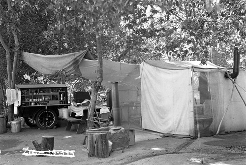 The Barnhill Camp at the Grotto Campground. View of large tent with stovepipe, dining fly, picnic table, and pickup truck with portable pantry mounted on the bed.