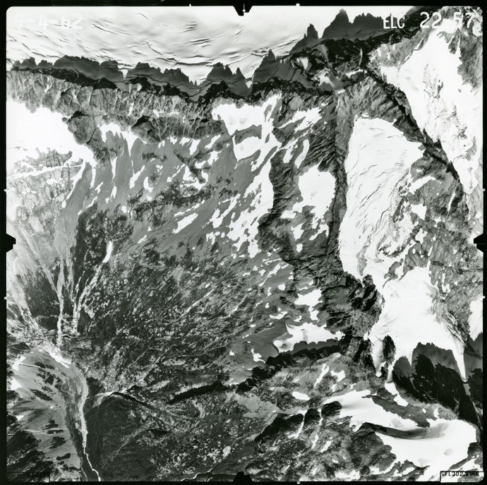 Black and white aerial photograph of glaciated mountain peaks and valleys.
