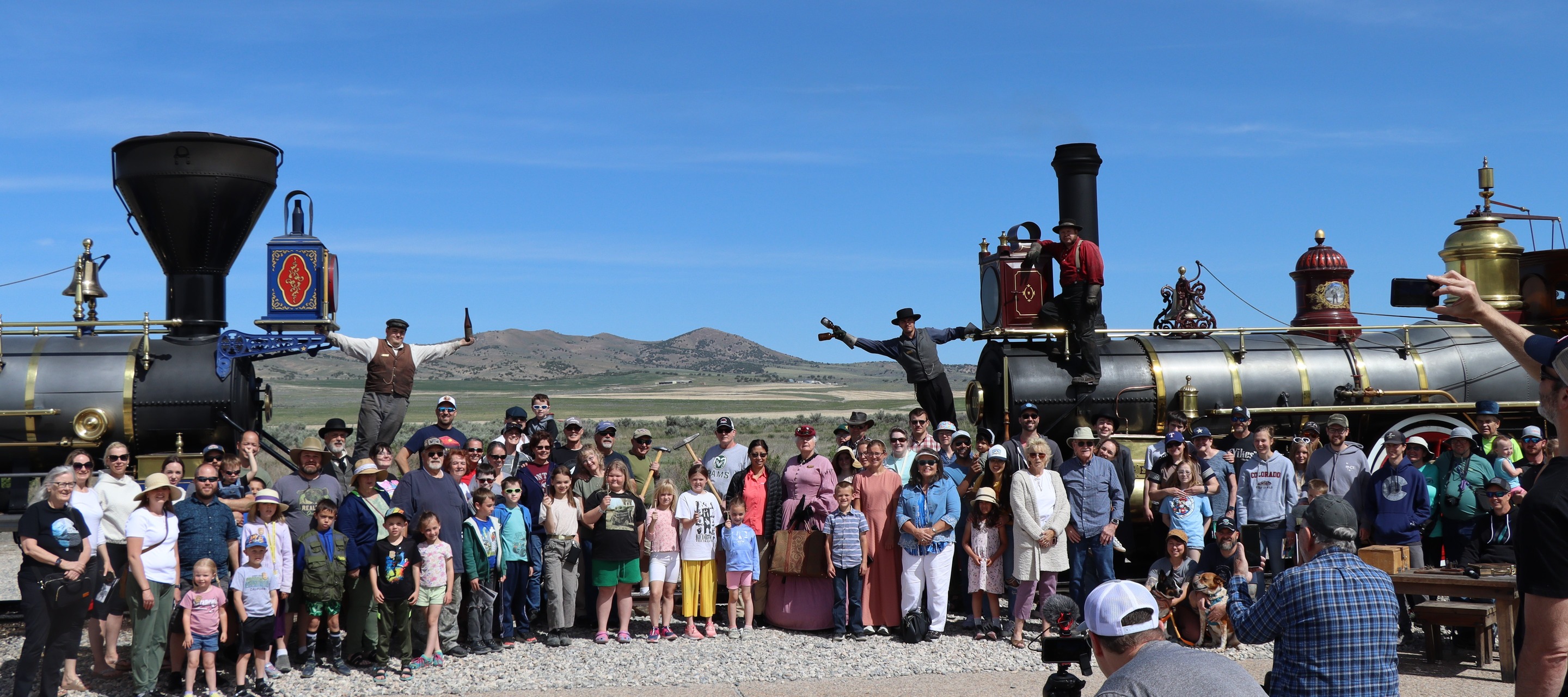 Locomotive staff and visitors gather around two locomotives to recreate the Champagne Photo